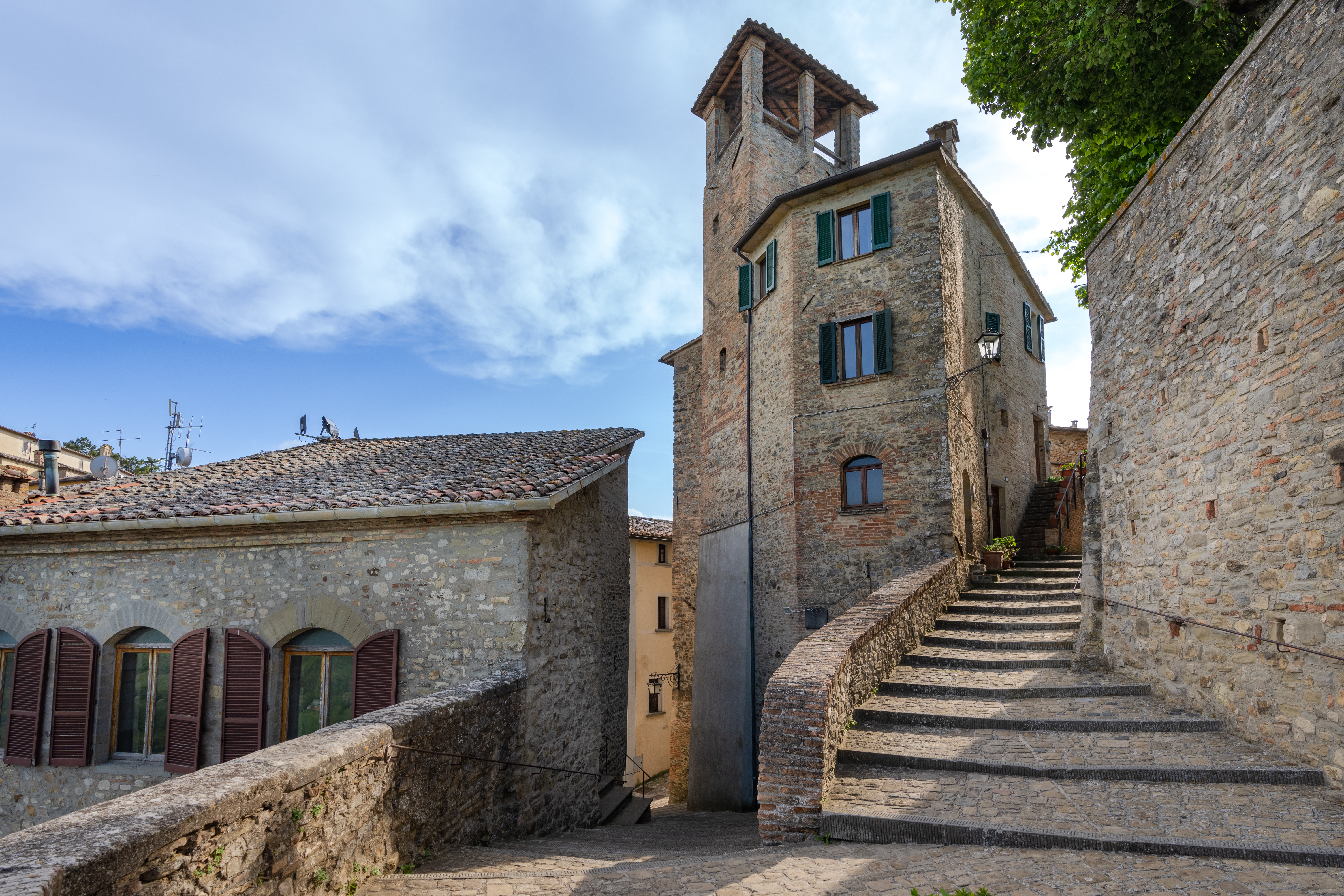 Stone steps leading to Montone’s Civic Tower, among medieval alleys and stone houses.