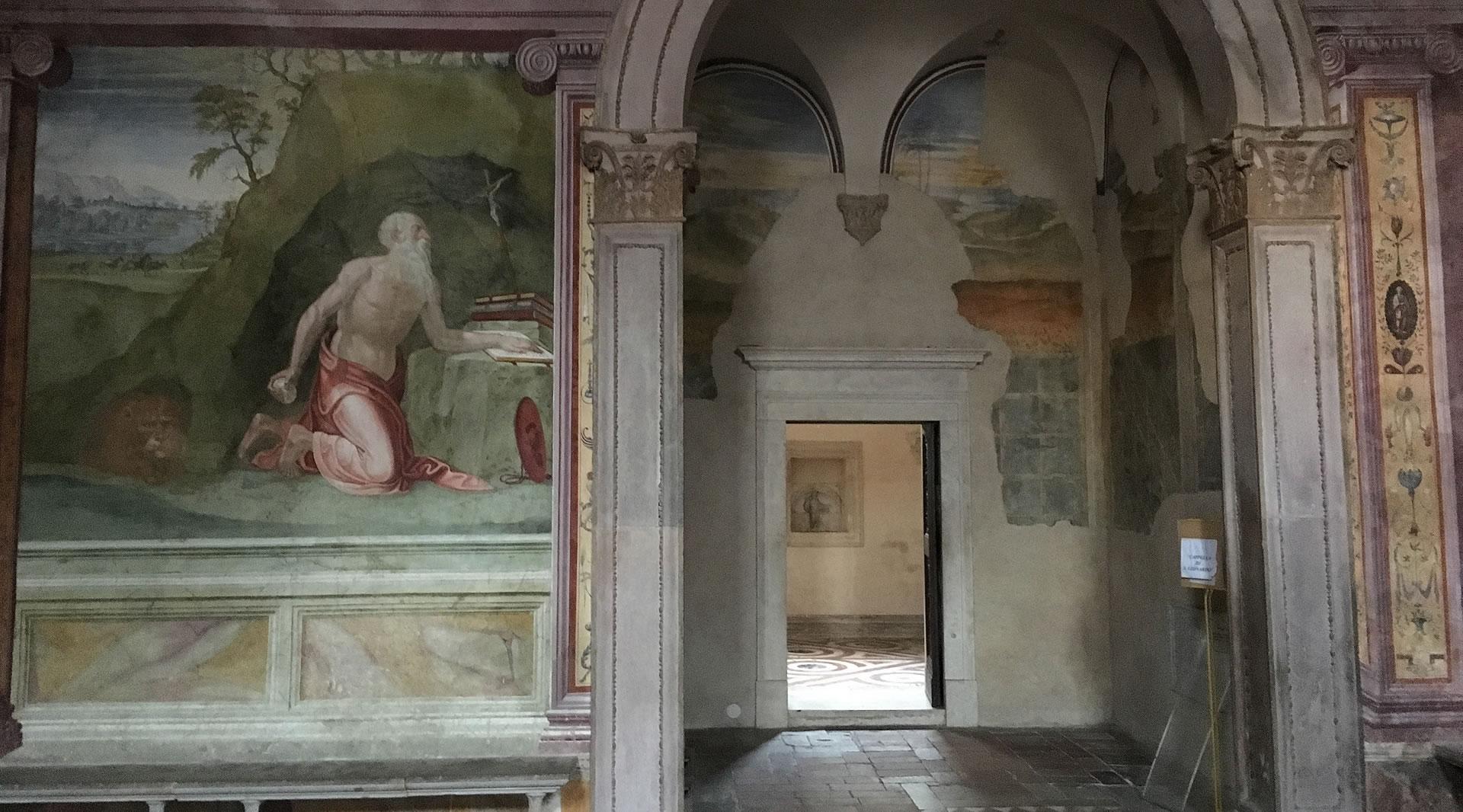 Renaissance-Fresko in der Kathedrale von Spoleto mit betendem Hl. Hieronymus, verzierten Säulen und einer offenen Tür zu einem weiteren Raum.