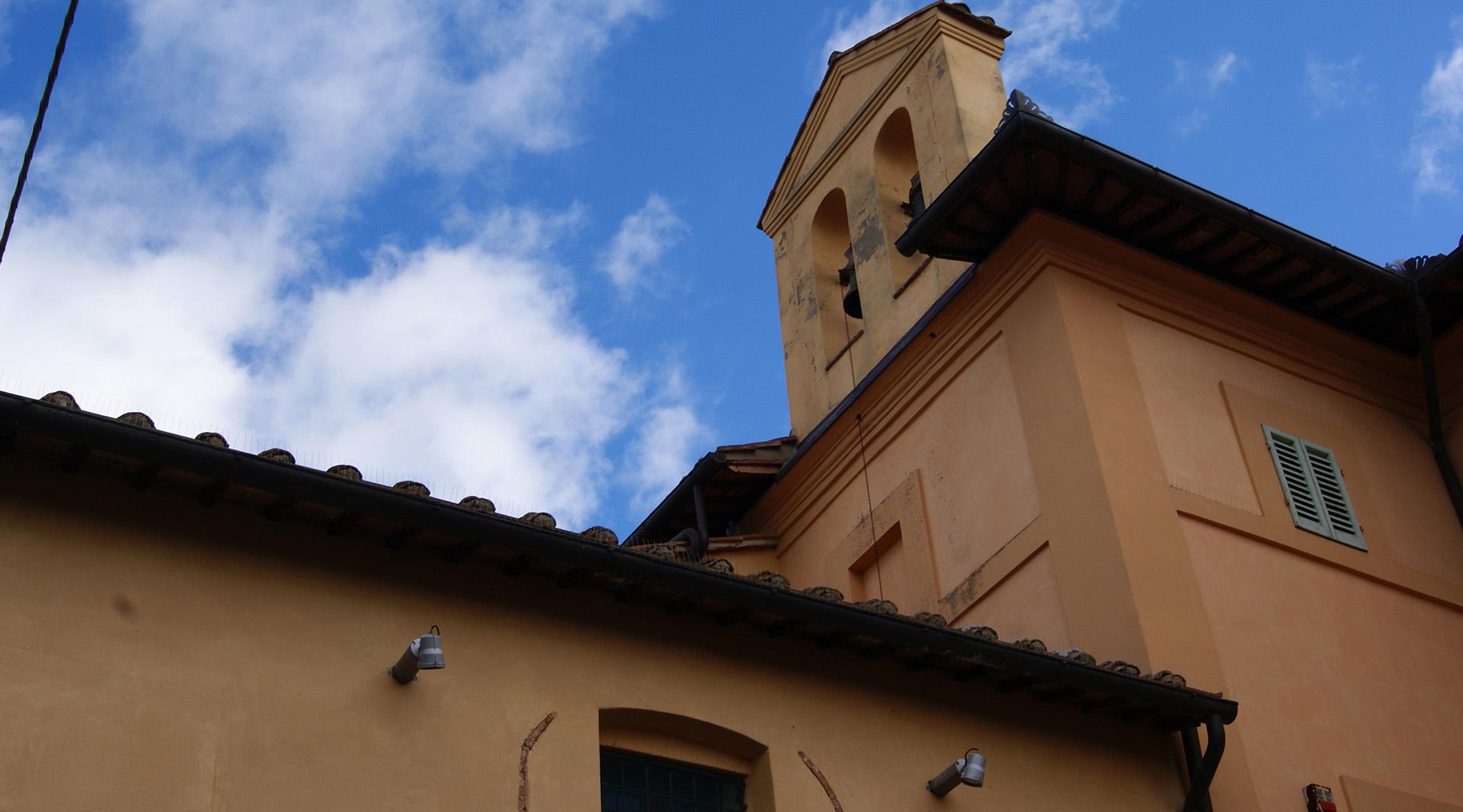 External perspective of the Church of San Sebastiano, featuring a sloping roof and a small side bell tower.