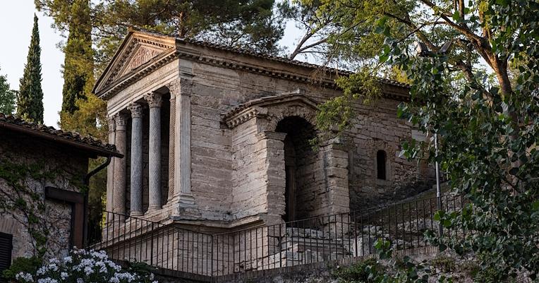 Vista del Tempietto sul Clitunno immerso nel verde, con la fronte con quattro colonne e ingresso laterale