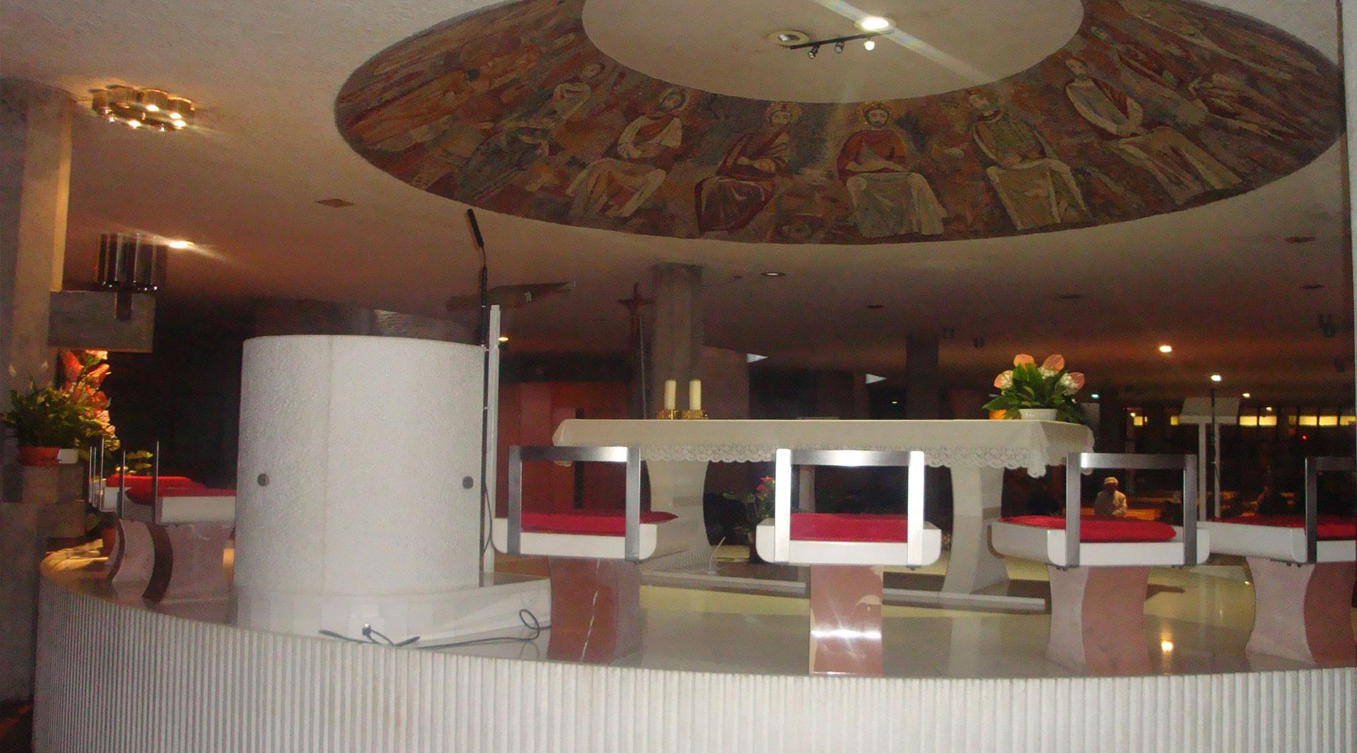 Interno della chiesa inferiore, con altare rialzato e sormontato dal mosaico circolare