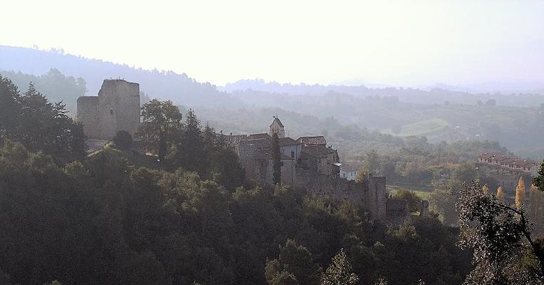 Poggio di Otricoli, antico borgo fortificato, si staglia tra i boschi umbri e le colline avvolte dalla foschia.