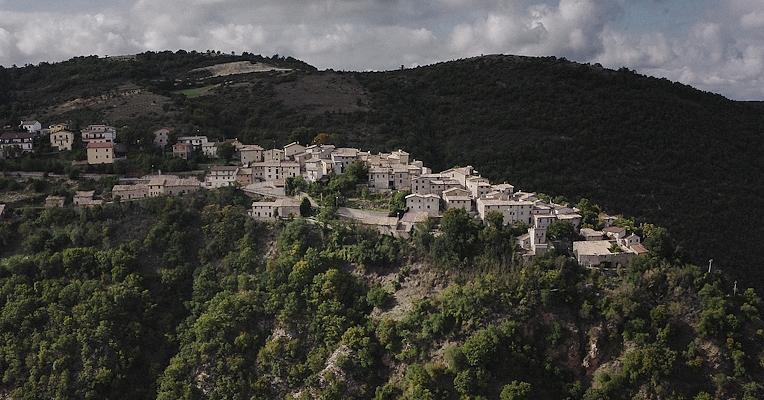 L’impianto del castello medievale di Poggiodomo poggiato sullo sperone di roccia in mezzo a natura incontaminata e verdi boschi