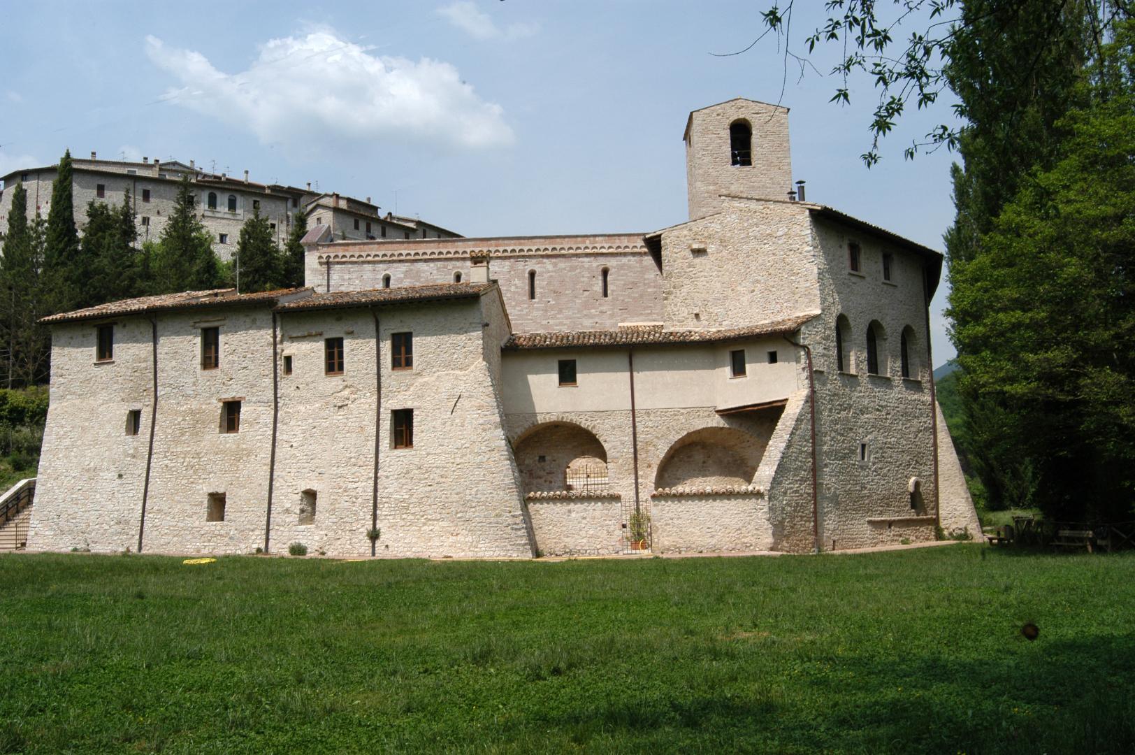 Green meadow behind the abbey of Saints Felice and Mauro, with the village of Castel San Felice in the background