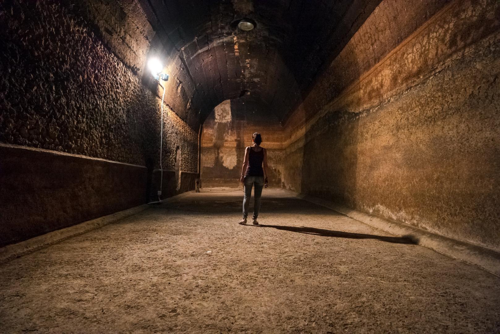 A person inside one of the rooms of the Roman cistern at Amelia