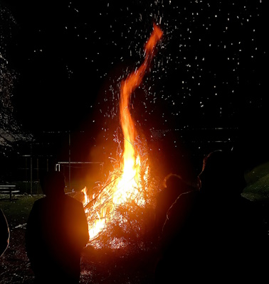 Image of a huge red and yellow flame rising into the night sky from one of the bonfires lit on the night of 9 December