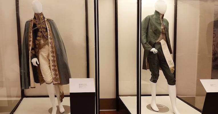 The two dresses of Count Valerio Zaccheo Travaglini. On the left, the ceremony dress in iridescent blue velvet with gold embroidery, and on the right, a day dress in green silk