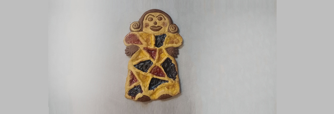 Two-tone tart shaped like a female figure, decorated with colourful jams and hand-moulded details.