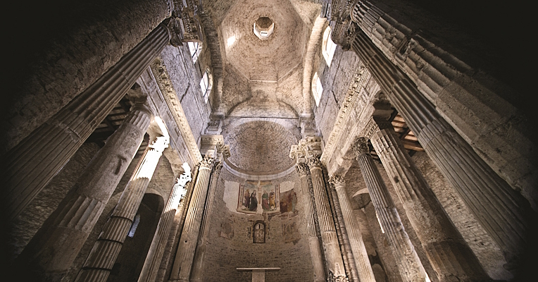 Interior of the basilica of San Salvatore with apse and spolia columns