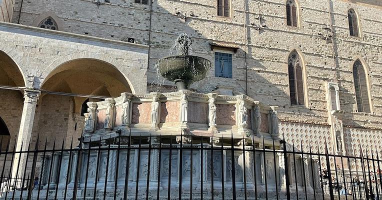 Fontana Maggiore of Perugia, with marble sculptures, water jets, and the background of the Cathedral of San Lorenzo.