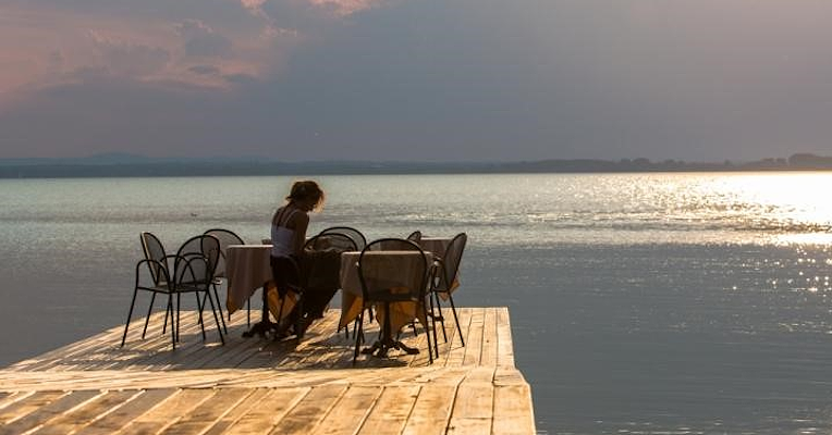 Table on a pier by the lake at sunset