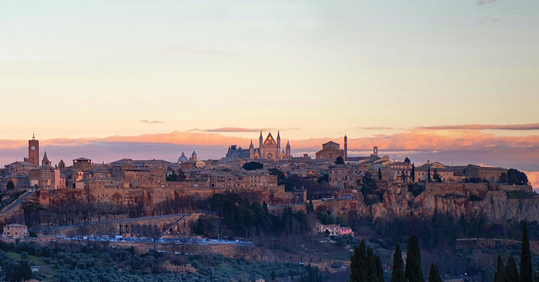 Panoramablick auf die Stadt Orvieto, vom Licht des Sonnenuntergangs beleuchtet, auf ihrem Tufffelsen gelegen.