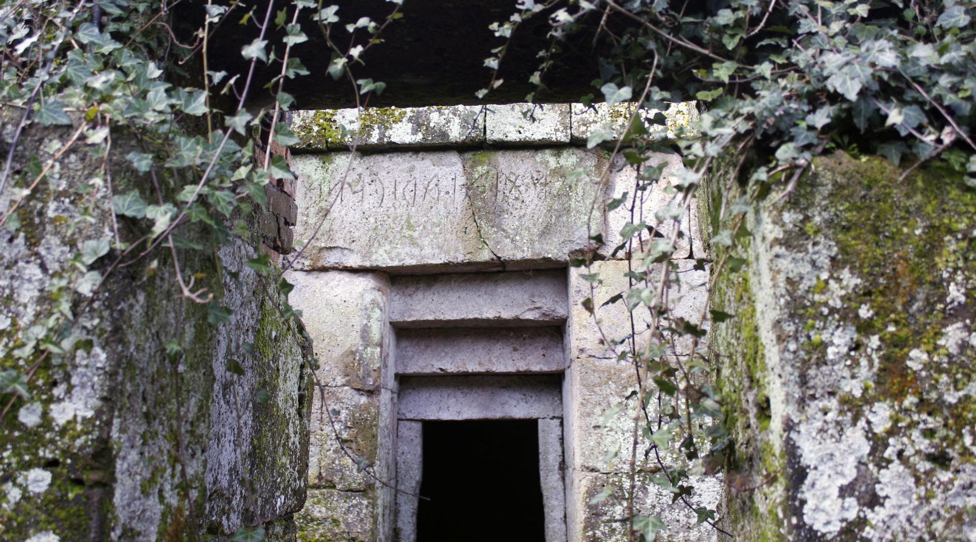 Entrance to an Etruscan stone tomb with the owner's name engraved on the lintel above the doorway.