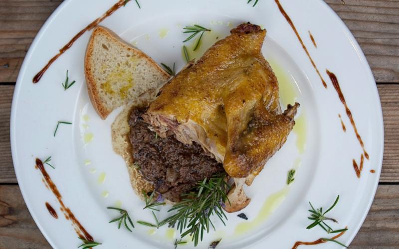Pintade rôtie sur croûton avec sauce aux foies de volaille, garnie de romarin, d’huile d’olive et de réduction balsamique.