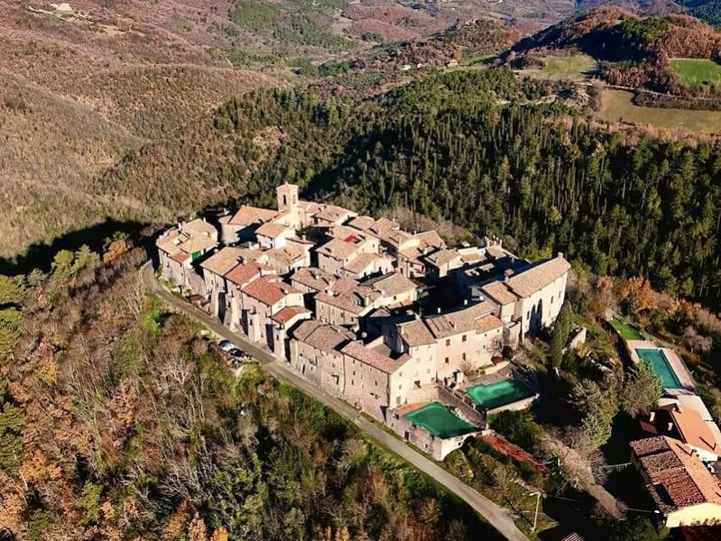 Aerial view of the medieval castle of Macerino in the Monti Martani, surrounded by Umbrian forests